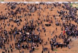 FILE - An aerial view of mourners preparing to bury the remains of Yazidi victims in a cemetery in Sinjar, Iraq, Feb. 6, 2021.