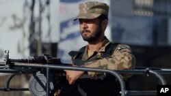 FILE - A Pakistani army soldier mans at a vehicle during a curfew in Rawalpindi.