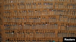 FILE - An aerial view of crosses casting shadows at the Parque Taruma cemetery is seen amid the coronavirus pandemic, in Manaus, Brazil, June 15, 2020.