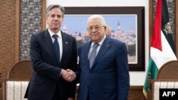 Presiden Otoritas Palestina Mahmud Abbas (kanan) dan Menteri Luar Negeri AS Antony Blinken berjabat tangan di awal pertemuan yang digelar di Muqata, kompleks kepresidenan di Ramallah, Tepi Barat, pada 30 November 2023. (Foto: Saul Loeb/Pool/AFP)