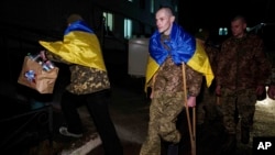 Ukrajinski vojnik Jevhen Liašenko koristi štake dok dolazi da se ponovo spoji sa svojom suprugom nakon povratka iz ruskog zarobljeništva, tokom razmjene ratnih zarobljenika na neidentifikovanoj lokaciji u Ukrajini, 30. decembra 2024.