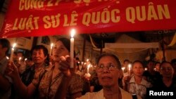 សកម្មជន Le Hien Duc ប្រឆាំង​នឹង​អំពើ​ពុករលួយ (រូប​ខាង​មុខ) និង​អ្នក​កាន់​សាសនា​កាតូលិក​កាន់​ភ្លើង​ទៀន​ក្នុង​ពេល​សូត្រ​ធម៌​មួយ​សម្រាប់​លោក​មេធាវី Le Quoc Quan នៅ​ព្រះ​វិហារ Thai Ha នៅ​ក្នុង​ក្រុង​ហាណូយ កាលពី​ថ្ងៃទី៣០ ខែមិថុនា ឆ្នាំ២០១៣។