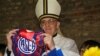 In this March 24, 2011 image released by the San Lorenzo de Almagro soccer team on March 13, 2013, Argentina's Cardinal Jorge Bergoglio holds up a small flag of the San Lorenzo soccer team in Buenos Aires, Argentina.