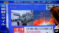 A woman walks past a TV screen broadcasting news of North Korea's missile launch, in Tokyo, Japan, Aug. 29, 2017. 