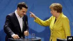 Kanselir Jerman Angela Merkel (kanan) menunjuk pada Perdana Menteri Yunani Alexis Tsipras dalam konferensi pers di Berlin (23/3). (AP/Michael Sohn)