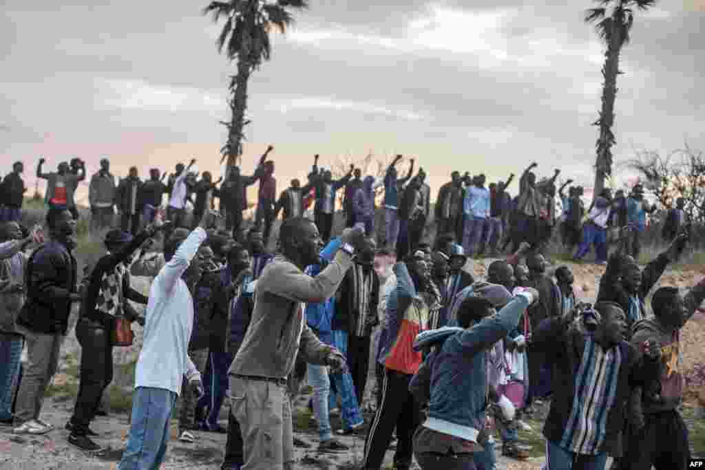 Para calon imigran dari Pusat Penampungan Sementara Imigran (CETI) bersorak menyemangati mereka yang akan menyeberangi pagar dekat Beni Enza, menuju wilayah utara kantong Spanyol Afrika di Melilla. Beberapa ratus orang mencoba untuk menyeberang menuju kota Spanyol itu, yang terletak di ujung utara Maroko. &nbsp;