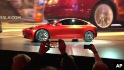 FILE - Tesla Motors unveils the new lower-priced Model 3 sedan at the Tesla Motors design studio in Hawthorne, California, March 31, 2016.