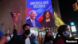 People celebrate media announcing that Democratic U.S. presidential nominee Joe Biden has won the 2020 U.S. presidential election, at Times Square in New York City, U.S. November 7, 2020. REUTERS/Jeenah Moon