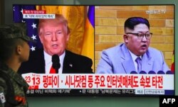 FILE - A South Korean soldier walks past a television screen showing pictures of U.S. President Donald Trump, left, and North Korean leader Kim Jong Un at a railway station in Seoul, March 9, 2018.