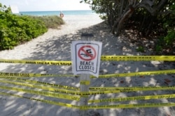 Pengumuman dilarang masuk tampan di pantai Surfside, Florida, Sabtu, 21 Maret 2020. (Foto: AP)