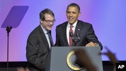 President Barack Obama talks with United Auto Workers [UAW] president Bob King after arriving to speak at the UAW conference in Washington, February 28, 2012.