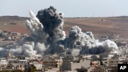 Asap mengepul akibat serangan udara AS terhadap posisi ISIS di Kobani, Suriah (22/10).