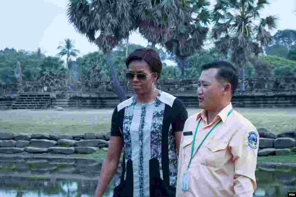 មគ្គុទ្ទេសក៍​ទេសចរណ៍​បង្ហាញ​ដល់​លោកស្រី Michelle Obama ក្នុង​ពេល​ដើរ​ទស្សនា​នៅ​បរិវេណ​ប្រាសាទ​អង្គរវត្ត នៅរសៀល​ថ្ងៃ​សៅរ៍​ ទី២១ ខែមីនា ឆ្នាំ២០១៥។