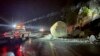 In this photo provided by Caltrans District 3, California Department of Transportation crews check large boulders that fell onto Highway 50 just east of Kyburz during a storm in El Dorado National Park, California, Jan. 1, 2023. 