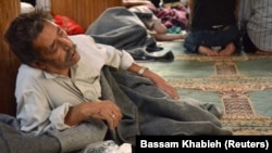 A survivor from what activists say is a gas attack rests inside a mosque in the Duma neighborhood of Damascus, Aug. 21, 2013. 