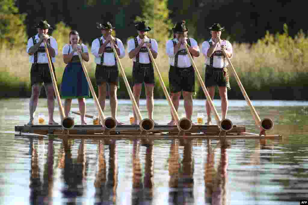 Musicians of the alphorn band "Holdersberger Alp-Traum-Bläser" perform their skills on a raft floating on the Elbsee lake near Aitrang, southern Germany, June 11, 2017.