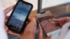 FILE - Fourteen-year-old Henry, left, and Angel, 15, view social media on their phones in Sydney, Australia, Nov. 8, 2024. In Australia, a high-profile social media ban for young adults under the age of 16 will take effect at the end of 2025.