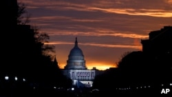 FILE - The U.S. Capitol building is illuminated during sunrise in Washington.