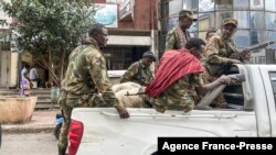 Des membres de la milice Amhara, qui combat aux côtés des forces fédérales et régionales contre la région du Tigré, dans le nord du pays, montent à l'arrière d'un pick-up dans la ville de Gondar, le 8 novembre 2020.