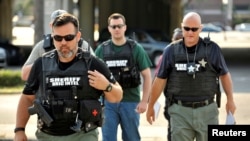 Para petugas tiba di kantor pusat Polisi Orlando untuk menyelidiki penembakan massal di klub malam Pulse di Orlando, Florida, 12 Juni 2016.