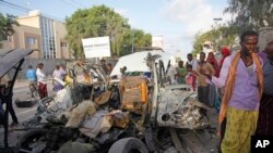 Des Somaliens s’assemblent près du lieu d’une attaque à la voiture piégée devant un restaurant en bord de mer à Mogadiscio, en Somalie, 26 août 2016. 