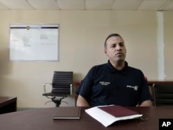 In this Jan. 9, 2018 photo, inspector Elexis Torres, is interviewed in Carolina, Puerto Rico. Torres heads a unit that is investigating eight homicides in a jurisdiction that includes the working-class city.