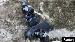 FILE - A woman's shoes lie on a street in Quezaltepeque, July 2, 2013. 