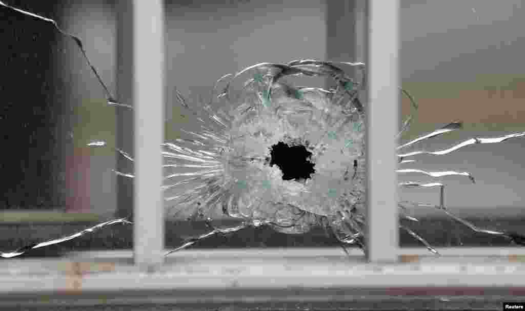 A bullet's impact is seen on a window at the scene after a shooting at the Paris offices of Charlie Hebdo, a satirical newspaper, Jan. 7, 2015. 