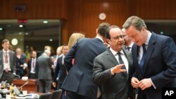 PM Inggris David Cameron (kanan) berbicara dengan Presiden Perancis Francois Hollande dalam pertemuan di KTT Uni Eropa di Brussels (28/6).
