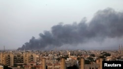 Asap mengepul di kota Benghazi akibat pertempuran antara militan Islamis dan pasukan Jenderal Khalifa Haftar (23/8). AS dan Eropa menentang campur tangan asing di Libya.