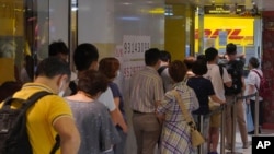 People queue up outside the DHL Express store in Hong Kong to send documents to the U.K. to apply for or renew what is known as a British National (Overseas) passport.
