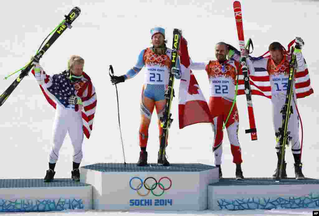 Men's super-G medalists from left, United States' Andrew Weibrecht (silver), Norway's Kjetil Jansrud (gold), Canada's Jan Hudec (bronze) and United States' Bode Miller (bronze) pose for photographers on the podium, Krasnaya Polyana, Russia, Feb. 16, 2014.