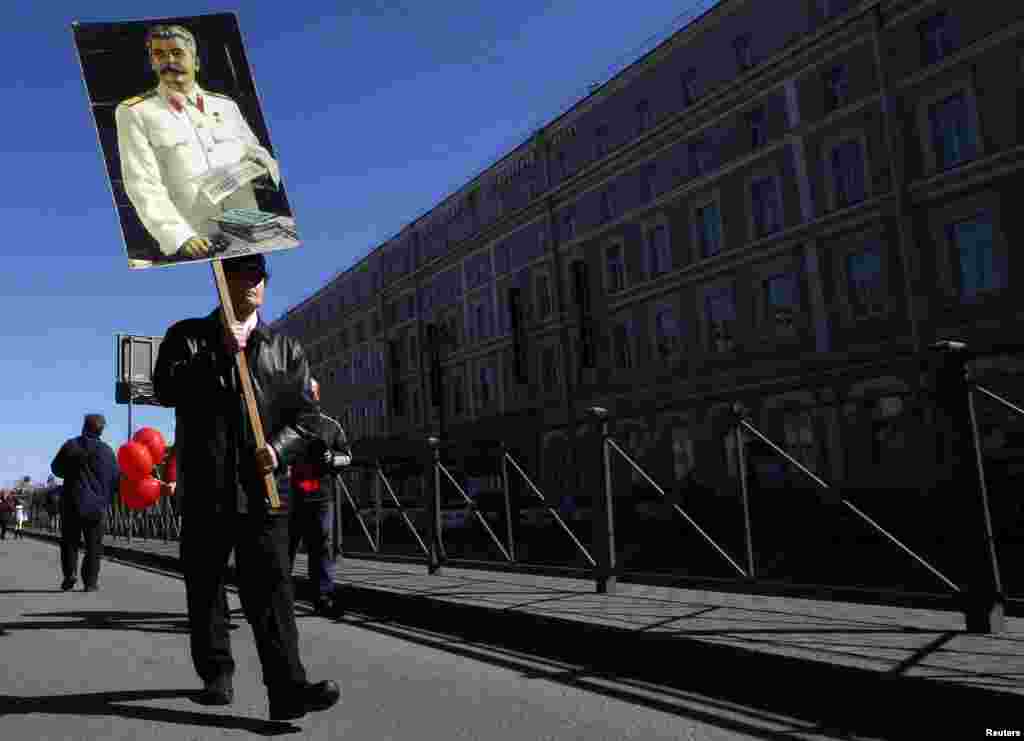 Rusiyanın Sankt-Peterburq şəhərində 1 May günü bir nəfər küçəyə Sovet diktatoru İosif Stalinin portreti ilə çıxıb. 1 may, 2013.