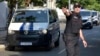 Policajac u Podgorici usmerava kolonu policijskih vozila koja prevoze osumnjilčene za državni udar u oktobru 2016. (Foto: AP/Risto Božović)