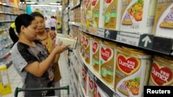 Seorang penjaga toko membantu seorang pelanggan untuk mencari produk susu di sebuah toko di Hefei, provinsi Anhui (Foto: dok). 