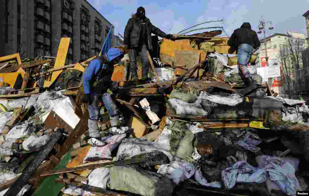 Anti-government protesters climb a barricade in central Kyiv, Feb. 20, 2014. 