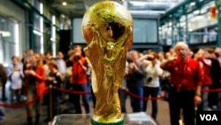 Des visiteurs autour du trophée de Coupe du Monde de la FIFA à Zurich, en Suisse, 26 mars, 2006. (AP Photo / Keystone, Eddy Risch )
