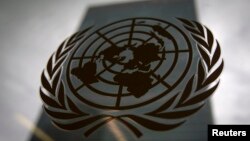 FILE - The United Nations headquarters building is pictured though a window, with the U.N. logo in the foreground.