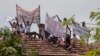 Para terpidana mati melakukan aksi protes di penjara Welikada di Kolombo, Sri Lanka, dengan memegang spanduk dari atap penjara, Jumat, 25 Juni 2021. (AP Photo/Eranga Jayawardena)