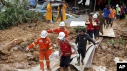 Members of a Myanmar rescue team carry a body at a landslide-hit area in Paung township, Mon State, Myanmar, Aug. 10, 2019. 