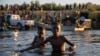 Two Haitians brothers cross the Rio Bravo natural border between Del Rio and Ciudad Acuña, Sept. 20, 2021. (Stephania Corpi/VOA)