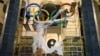 In this Oct. 28, 2013 photo, workers fix the Olympic emblem at an entrance to the railway station of Russia's Black Sea resort of Sochi, Russia.