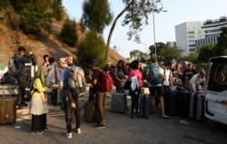 International students of the Chinese University of Hong Kong evacuate with their suitcases after anti-government protesters occupied the campus, in Hong Kong, Nov. 15, 2019.