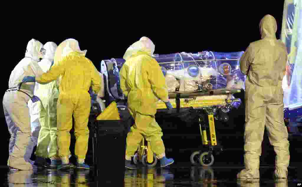 Para dokter dan petugas medis memindahkan&nbsp;Manuel Garcia Viejo, seorang pendeta Spanyol yang didiagnosa terjangkit Ebola saat bekerja di&nbsp;Sierra Leone, ke dalam ambulans di pangkalan militer&nbsp;Torrejon de Ardoz dekat Madrid, Spanyol (22/9). 