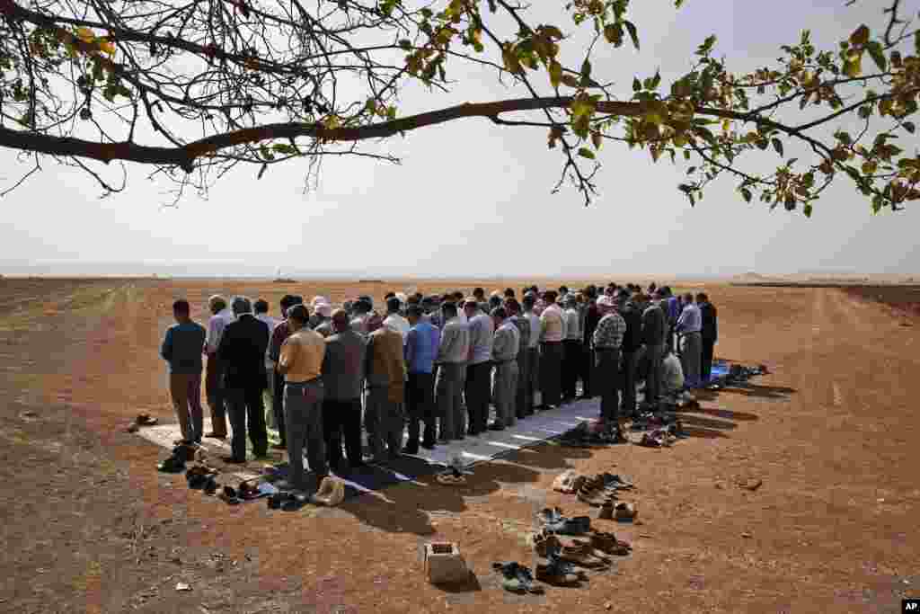 Turkish Kurds offer their Friday prayers in support of the Syrian Kurds in nearby Kobani, Syria, Oct. 10, 2014. 