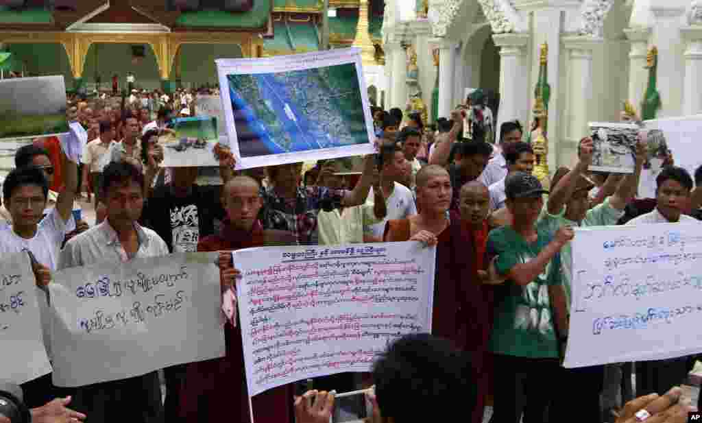 Buddhist monks and ethnic Rakhine people hold placards at Shwedagon pagoda in Rangoon, Burma, June 10, 2012.