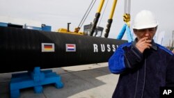 Трубопровід із написом "Росія" та прапорами РФ і Німеччини. 