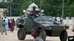 (File) Nigerian soldiers ride on the armored tank in Maiduguri, Nigeria. 