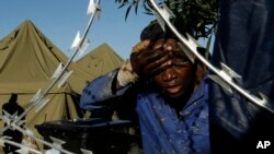 Un homme se lave le visage à l'extérieur d'un centre d'hébergement pour étrangers déplacés dans l'est de Johannesburg, Afrique du Sud, mardi 21 avril 2015.