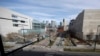 FILE - Normally bustling with folks heading to the city jail or courthouse, two people walk along the path between the two judicial complexes as the fear of coronavirus forces workers to stay home, in Denver, March 16, 2020.
